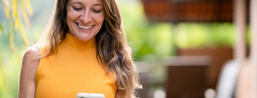 Woman in yellow on cell phone outside