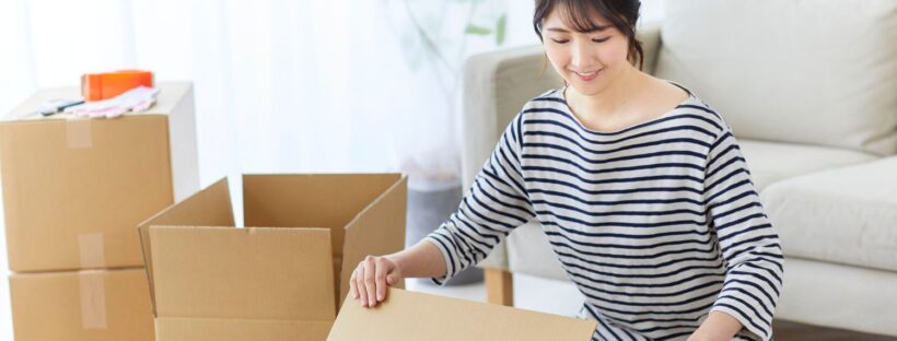 Woman packing up boxes in living room